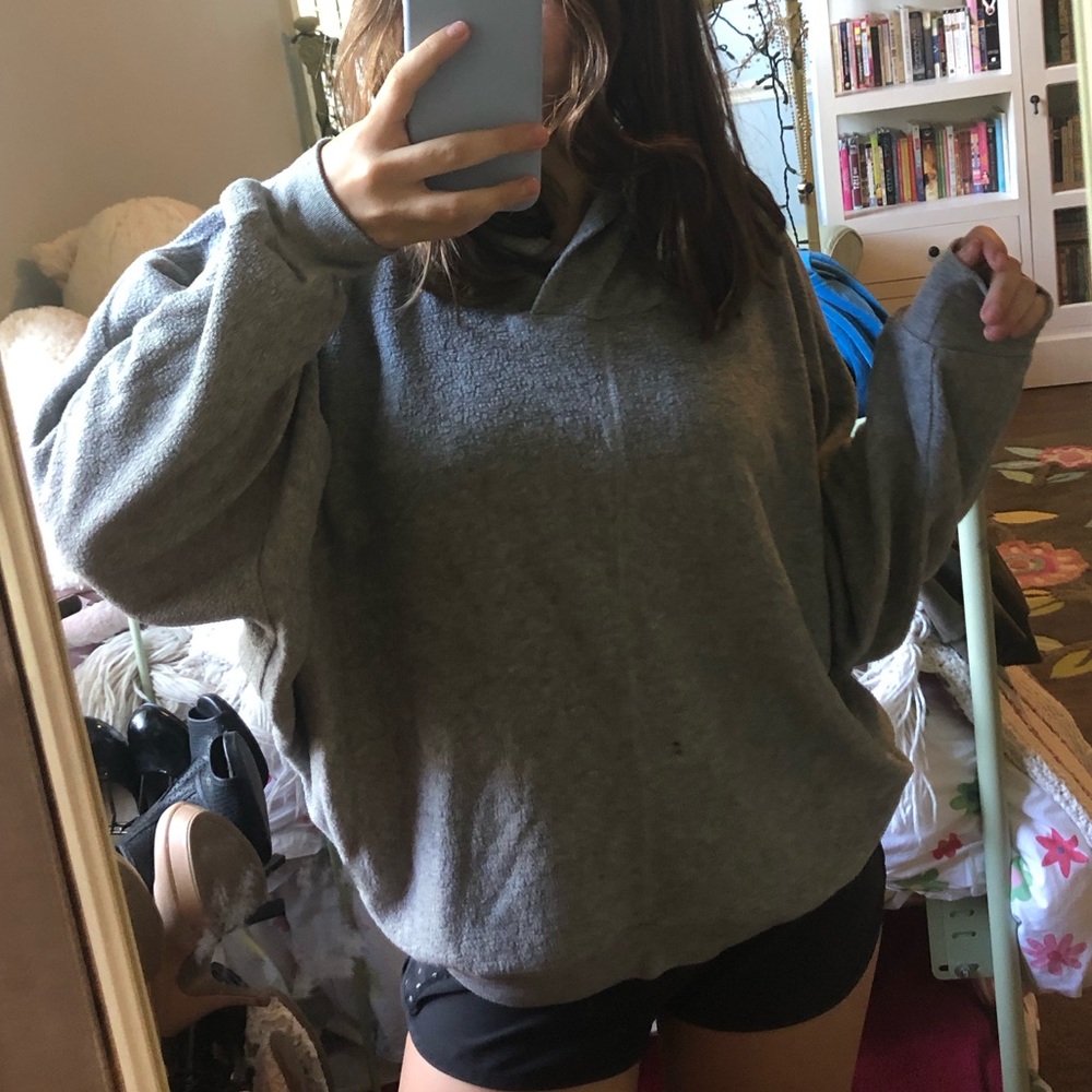 out from under gray oversized sweatshirt